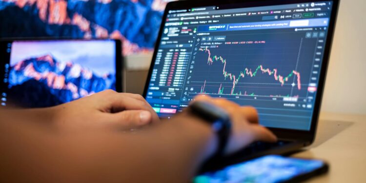 A person analyzing cryptocurrency charts on a computer screen with Ethereum logos.