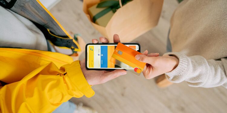 A DoorDash delivery worker holding a smartphone displaying a stablecoin payment app.