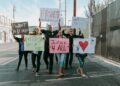 Protesters holding signs during a march against ICE shooting in California.