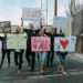 Protesters holding signs during a march against ICE shooting in California.
