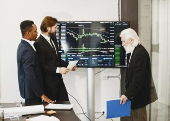 Group of diverse individuals discussing cryptocurrency trading at a financial conference.