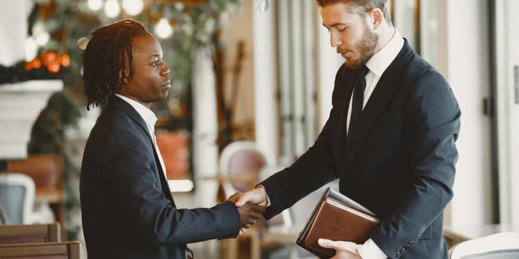 A handshake between business leaders set against a digital prediction market backdrop.