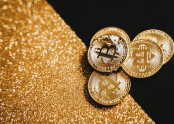 Gold bars and cryptocurrency symbols representing OCBC's tokenized gold fund initiative.