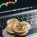 Bitcoin coins stacked with financial graphs and dollar signs, symbolizing crypto market growth.