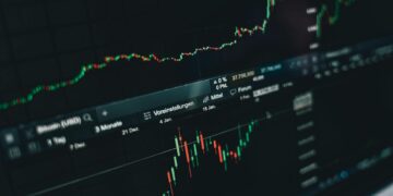 A digital chart shows a sharp decline in Bitcoin value against a backdrop of rising oil prices.