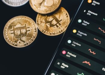 A smartphone displaying the Tether wallet app with USDT and Bitcoin transaction features.