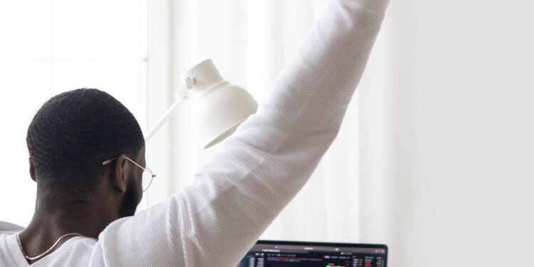A miner celebrates with a laptop and Bitcoin graphics after winning a significant block reward.