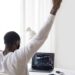 A miner celebrates with a laptop and Bitcoin graphics after winning a significant block reward.