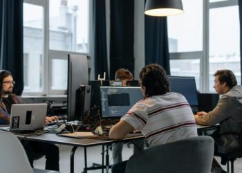 Team of engineers working on AI technology in a modern office setting with Pentagon models.