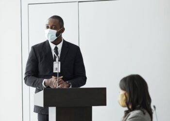 Texas Attorney General Ken Paxton speaking at a podium, discussing financial regulations.