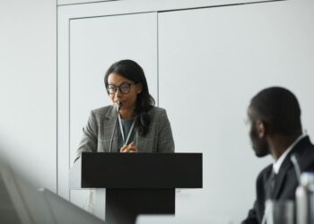 OpenAI CEO speaking at a podium about AI superintelligence regulations and risks.