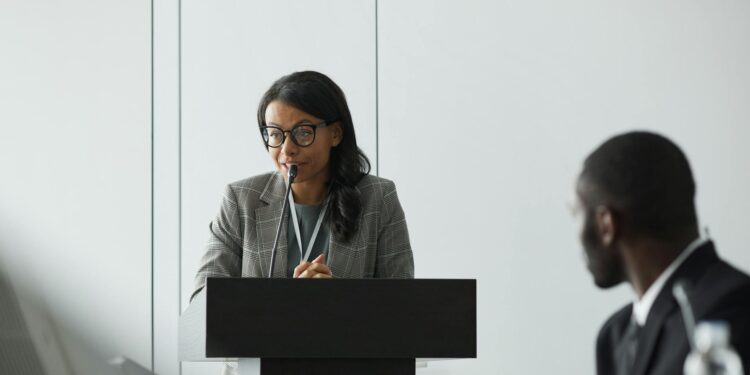 OpenAI CEO speaking at a podium about AI superintelligence regulations and risks.