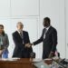 Executives from Startale Group and Sunnyside Labs shake hands in a tech conference setting.