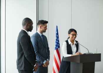 Trump speaking at a podium, emphasizing the potential civilian fallout from U.S.-Israel military actions.