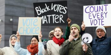 Protesters holding signs advocating for crypto regulations outside a government building.