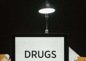 Law enforcement officers inspecting cryptocurrency trading devices during FCA raids in the UK.