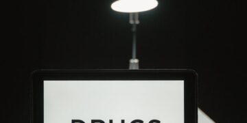 Law enforcement officers inspecting cryptocurrency trading devices during FCA raids in the UK.