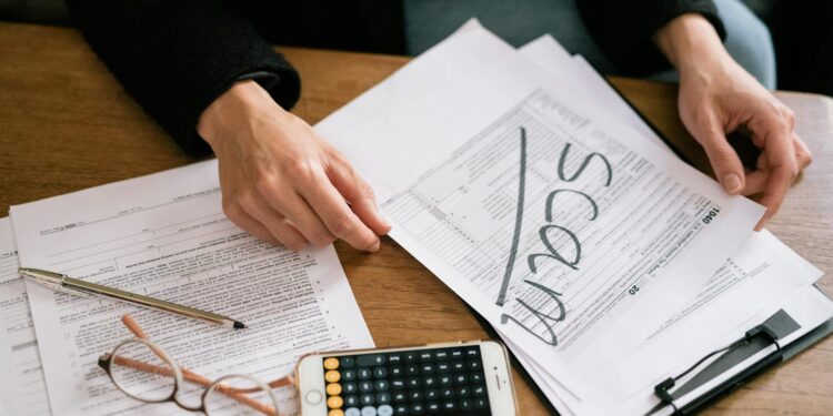 An investor examines financial documents, symbolizing the threat of impersonation scams.