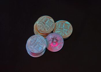 Bitcoin coins stacked with a calculator and financial reports, symbolizing crypto investment.