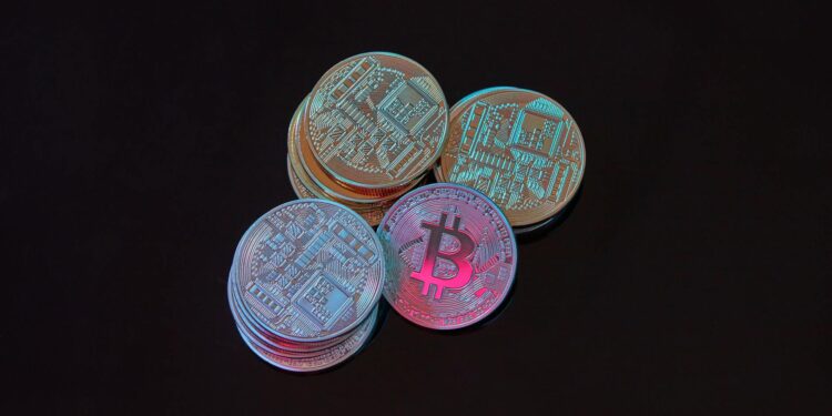 Bitcoin coins stacked with a calculator and financial reports, symbolizing crypto investment.