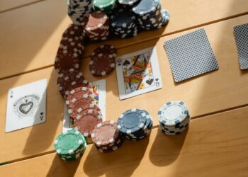 Player card with a QR code displayed on a smartphone beside gambling chips and cash.