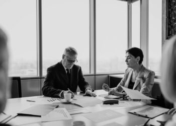 Business meeting with finance professionals discussing a takeover deal.