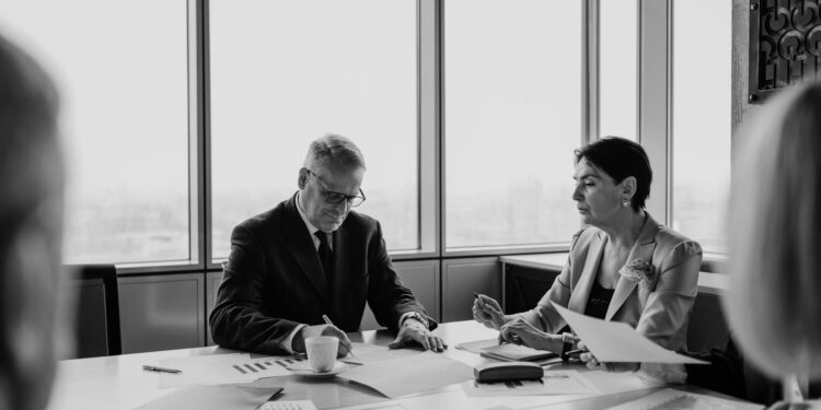 Business meeting with finance professionals discussing a takeover deal.