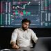 A trader monitoring cryptocurrency prices on a digital screen with Bitcoin and Ethereum charts.
