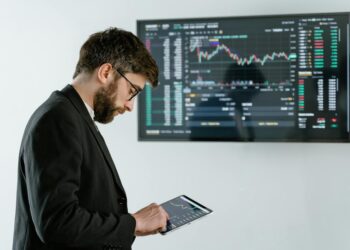 A trader analyzes charts on a digital device, symbolizing crypto trading advancements.