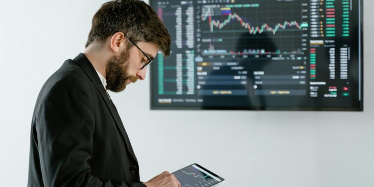 A trader analyzes charts on a digital device, symbolizing crypto trading advancements.