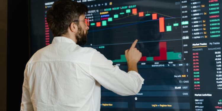 Analysts discussing crypto compliance data on digital screens at a conference.