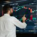Analysts discussing crypto compliance data on digital screens at a conference.