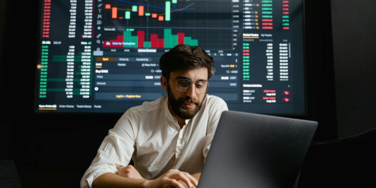 Crypto trader analyzing charts on a laptop, with oil barrel and dollar signs in the background.