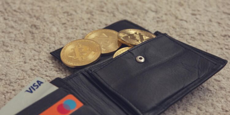 A digital illustration of a cracked cryptocurrency wallet with coins spilling out.