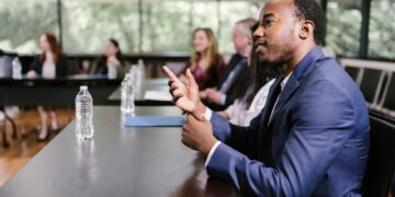 A group of bankers discussing cryptocurrency regulations around a conference table.