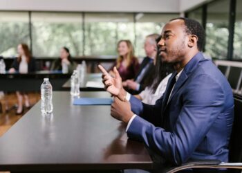 A diverse group of professionals discussing AI policy at a conference table.