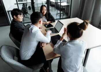 Employees in an office discussing restructuring and job cuts at a tech startup.