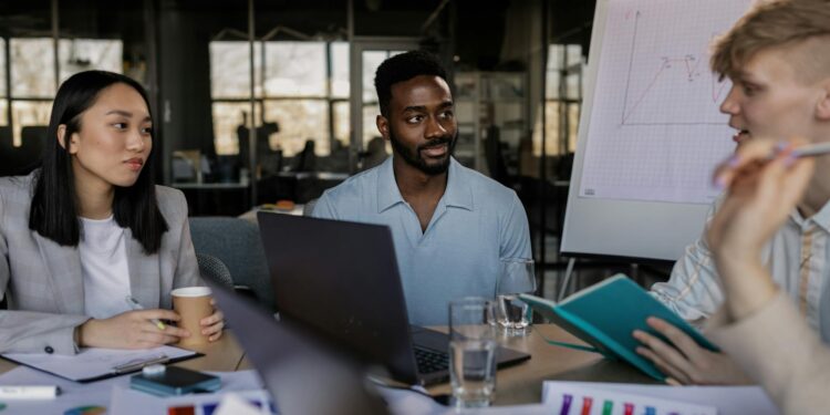 Marketing team meeting with crypto graphics and charts in a modern office setting.