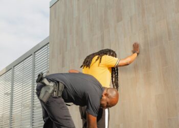 Police officers inspecting confiscated crypto transaction equipment and manga materials.