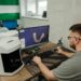 A technician analyzes gemstones with advanced AI software in a lab setting.
