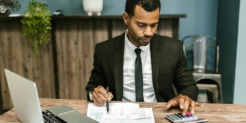 A businessman checking stablecoin account balances on a laptop.