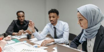 Employees in a meeting room appear concerned as Meta announces significant layoffs.