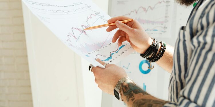 Anthropic's logo alongside financial charts and stock market graphics in a corporate setting.