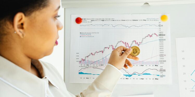 A financial analyst reviews charts and reports on cryptocurrency investments.