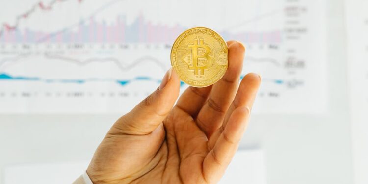 Brett Redfearn smiling, standing in an office with financial charts and crypto assets in background.