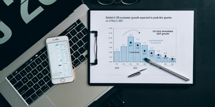 Goldman Sachs logo with a backdrop of digital currency graphics and financial charts.