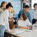 A group of diverse creators discussing blockchain projects in a collaborative workspace.