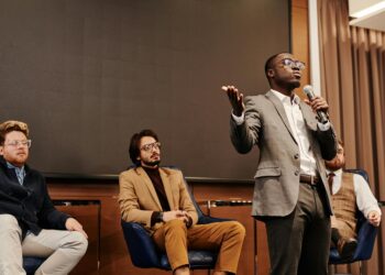 Ben Delo speaking at a conference, discussing cryptocurrency and financial reform initiatives.