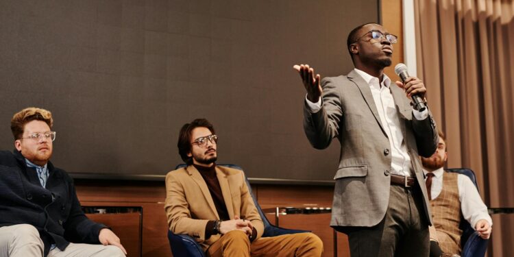 Ben Delo speaking at a conference, discussing cryptocurrency and financial reform initiatives.