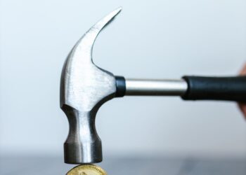 A gavel and cryptocurrency coins on a table, symbolizing legal actions in finance.